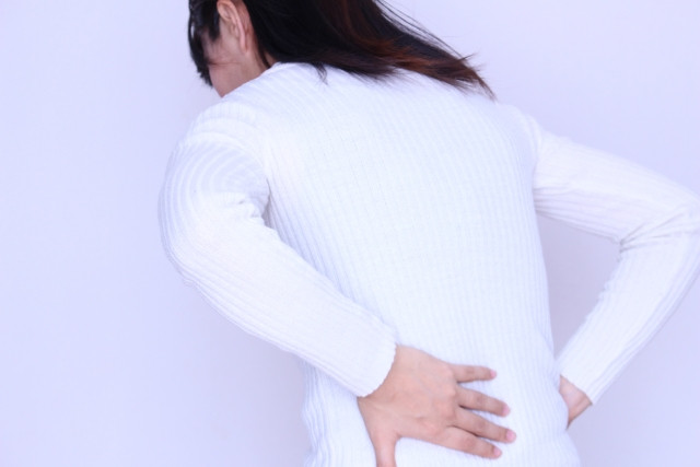 梨状筋症候群によって痛みを感じている女性写真